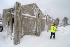 HAMBURG, NY - DECEMBER 27: Jack Stanton checks his ice encrusted home after being battered with waves from Lake Erie along Hoover Beach on December 27, 2022 in Hamburg, New York. The historic winter storm Elliott dumped up to four feet of snow on the area leaving thousands without power and twenty eight confirmed dead in the city of Buffalo and the surrounding suburbs. (Photo by John Normile/Getty Images)
